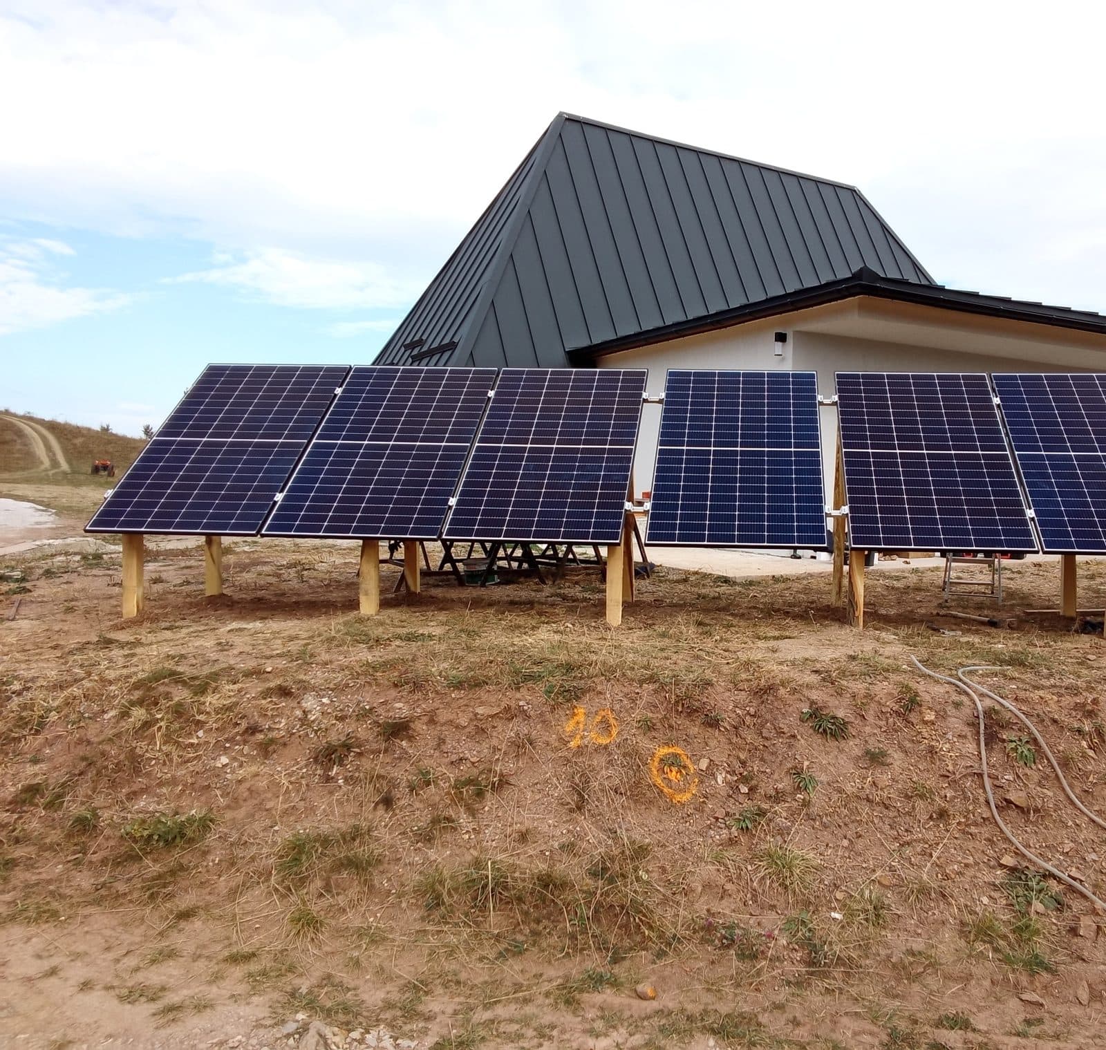 Ground-mounted solar panels beside a house in Ponor, Alba